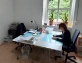 Auf dem Bild ist ein Büro und eine Frau zu erkennen.