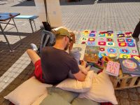 Auf dem Bild ist eine Person und ein Kind zu sehen, die gemeinsam ein Buch lesen.