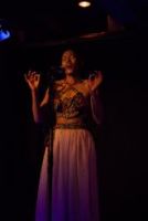 Auf dem Bild ist die Sängerin Thabilé auf der Bühne zu erkennen. 